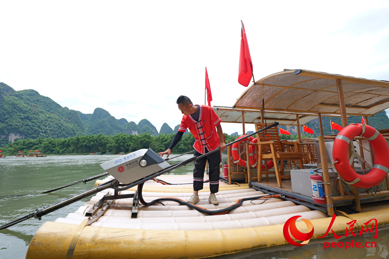 筏工郑海波在操作竹筏。人民网 梁章晖摄